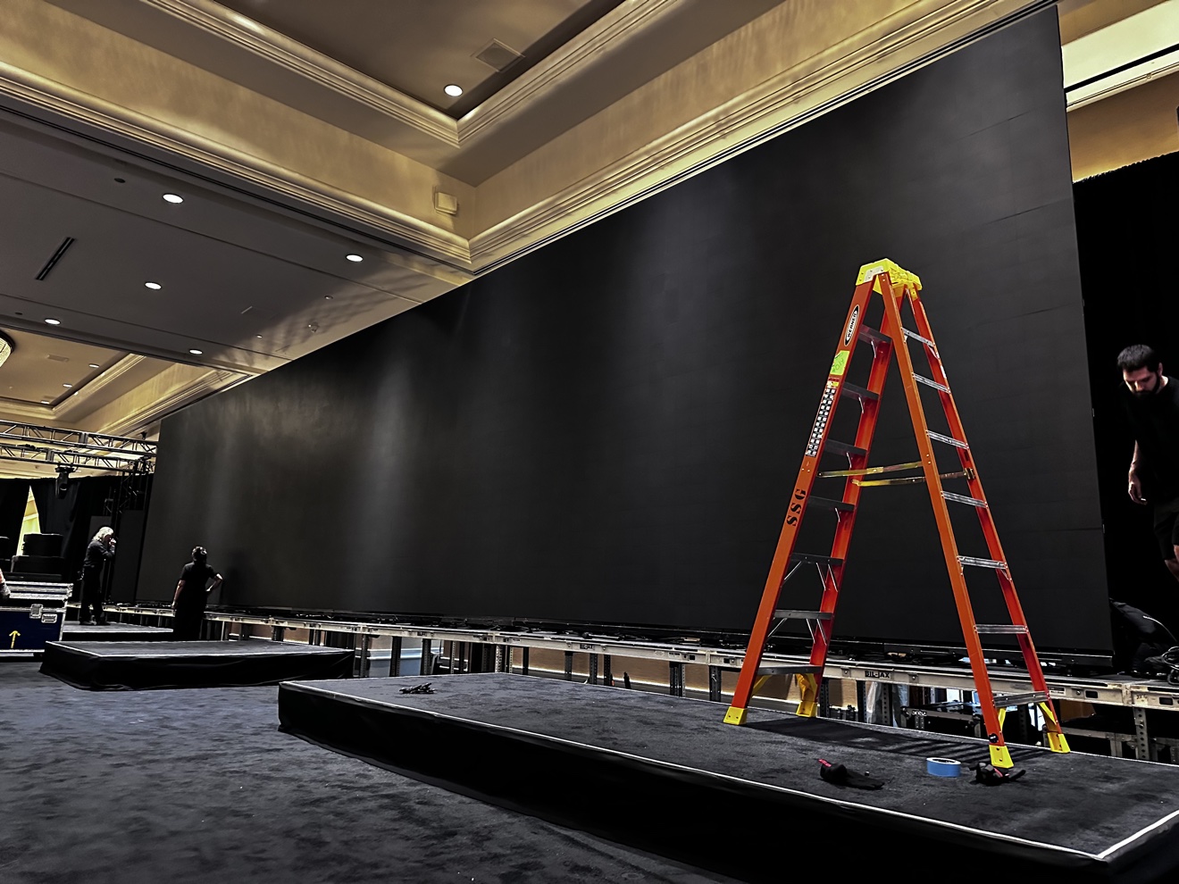 LED video wall being installed with a ladder and production equipment nearby