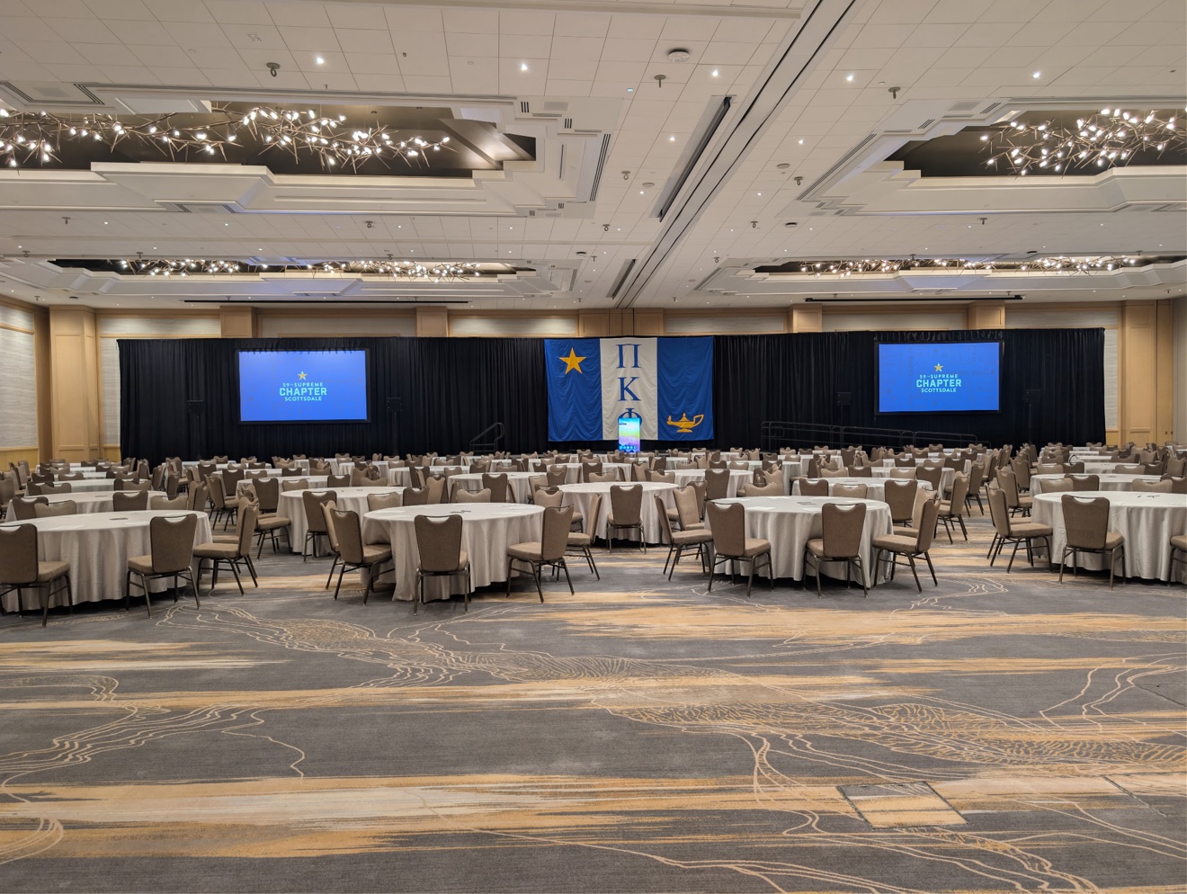 Formal gala ballroom arranged with tables and event lighting