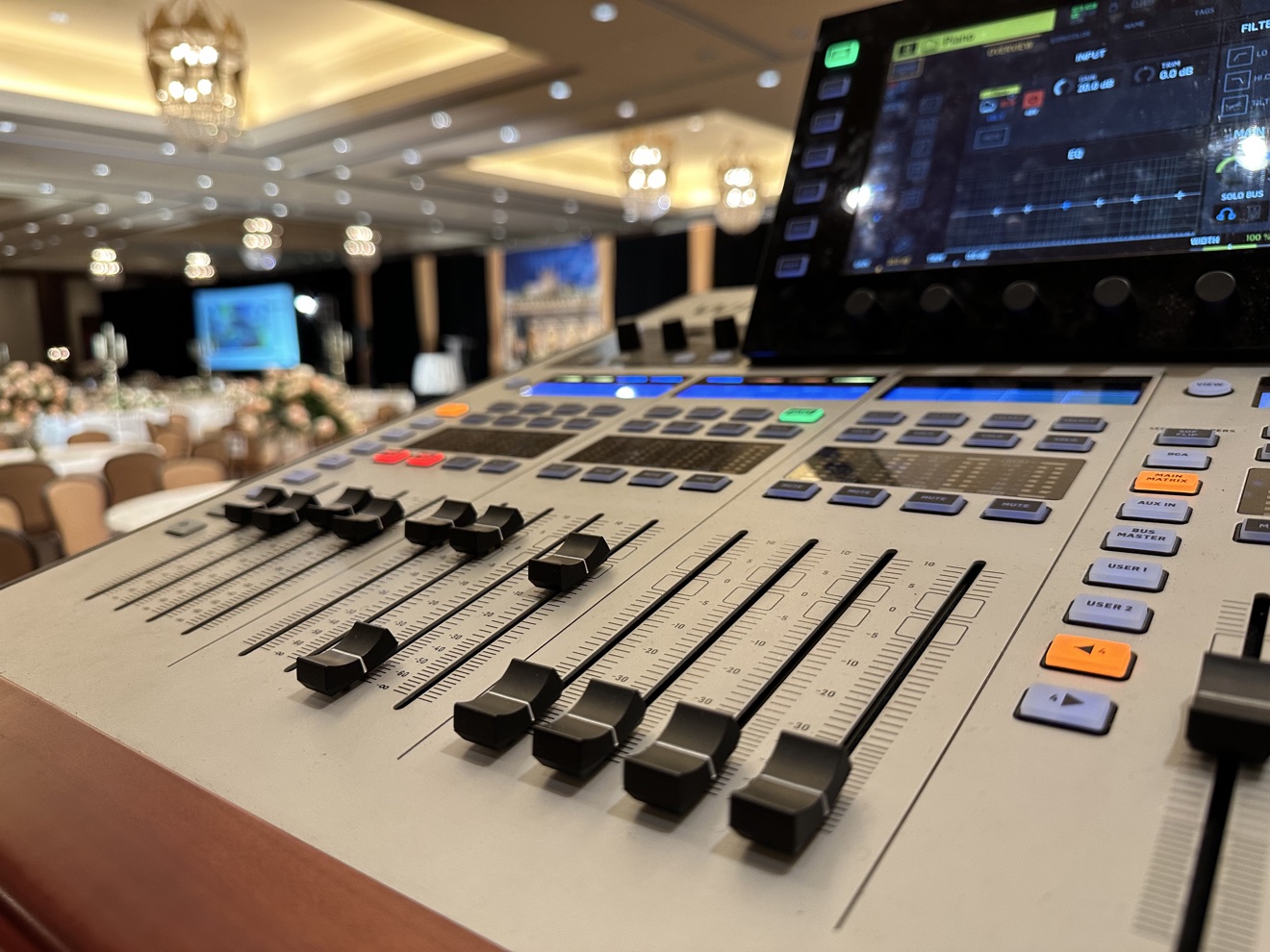 Close-up view of an audio mixing console during a live event