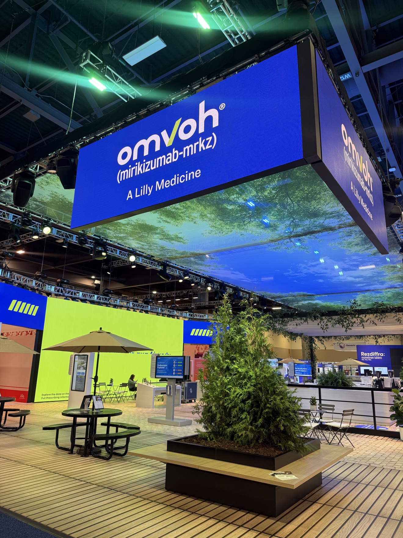Busy trade show floor with exhibit booths and production lighting